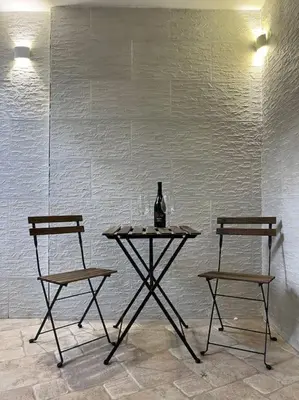 a table with a bottle of wine and two chairs at Full Semi-Garden apartment in Villa at Mondello in Palermo