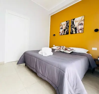 a bedroom with a bed with two pictures on the wall at Il Moro di Ballarò - Palermo Rooms in Palermo
