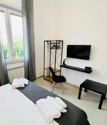 a bedroom with a bed and a chair and a television at Il Moro di Ballarò - Palermo Rooms in Palermo