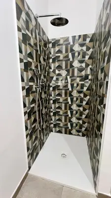 a bathroom with a shower with geometric tiles at Il Moro di Ballarò - Palermo Rooms in Palermo
