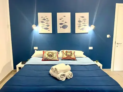 a blue bedroom with a bed with towels on it at Il Moro di Ballarò - Palermo Rooms in Palermo