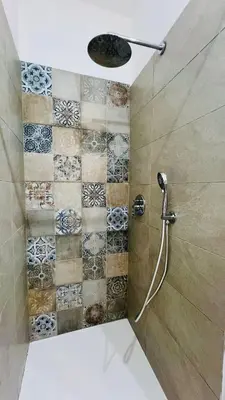 a bathroom with a shower with a tile wall at Il Moro di Ballarò - Palermo Rooms in Palermo