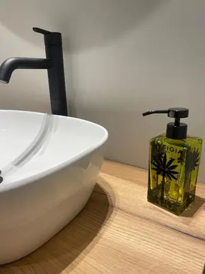 a bathroom sink with a soap dispenser next to it at Zahir Suite Apartment in Palermo