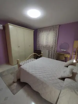 a bedroom with a large bed and purple walls at V&J appartamenti in Carini