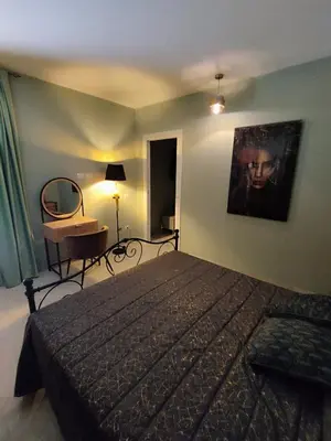 a bedroom with a bed and a table and a chair at V&J appartamenti in Carini