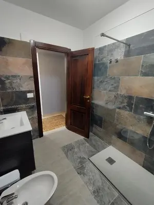 a bathroom with a toilet and a sink and a shower at V&J appartamenti in Carini