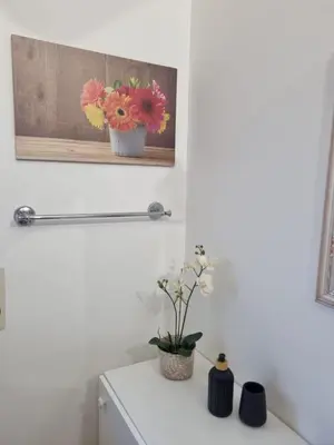 a white bathroom with flowers on a shelf at CITY HOUSE & FREE PARKING by Perry-Holiday moderno, panoramico e comodo fino a 6 ospiti in Palermo