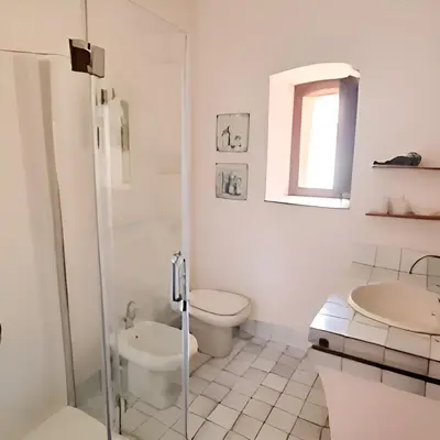 a white bathroom with a toilet and a sink at Antico frantoio in Palermo