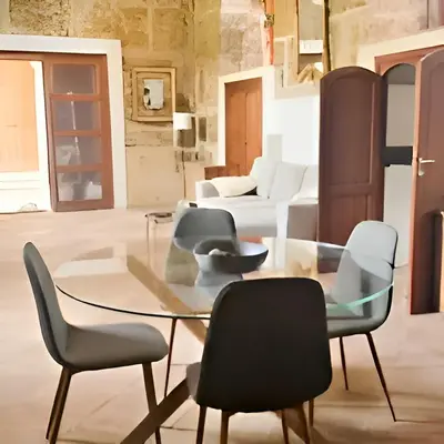 a dining room with a glass table and chairs at Antico frantoio in Palermo