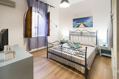 a bedroom with a black bed and a table at Casa Trionfante in Santa Flavia