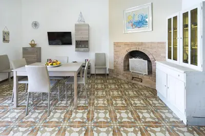 a dining room with a table and a fireplace at Casa Trionfante in Santa Flavia