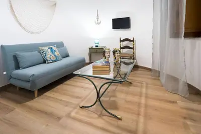 a living room with a couch and a glass table at Casa Trionfante in Santa Flavia