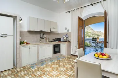 a kitchen with a table with a bowl of fruit on it at Casa Trionfante in Santa Flavia