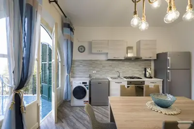 a kitchen with a table and a kitchen with a refrigerator at Terrazza Trionfante in Santa Flavia