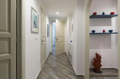 a hallway with white walls and wooden floors at Terrazza Trionfante in Santa Flavia