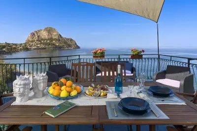 a table with a bowl of fruit on a balcony at Terrazza Trionfante in Santa Flavia