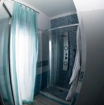 a bathroom with a shower with a shower curtain at BluSunset Home Capaci in Capaci