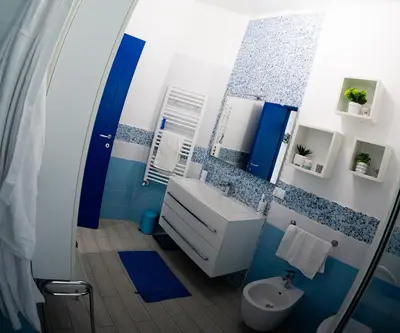 a blue and white bathroom with a sink and a toilet at BluSunset Home Capaci in Capaci