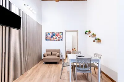 a living room with a table and a chair at Cappuccini 62 House in Palermo