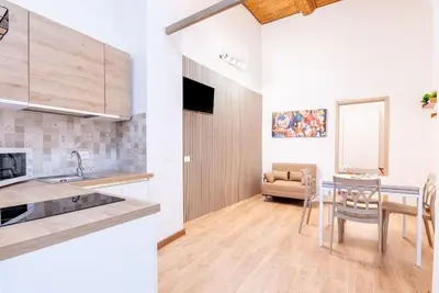 a kitchen and a dining room with a table and chairs at Cappuccini 62 House in Palermo