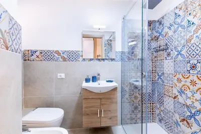 a bathroom with a toilet and a sink and a shower at Cappuccini 62 House in Palermo
