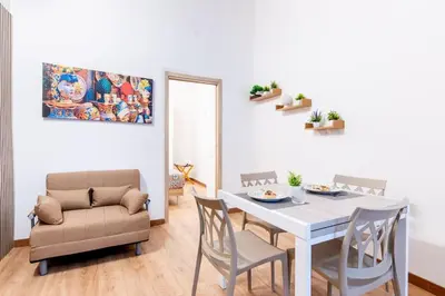 a dining room with a white table and chairs at Cappuccini 62 House in Palermo