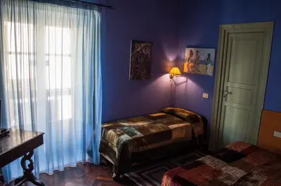 a blue room with two beds and a window at La dimora del genio in Palermo
