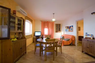 a kitchen with a table and a bedroom with a bed at Balconi Sul Mare Appartamenti in Castellammare del Golfo