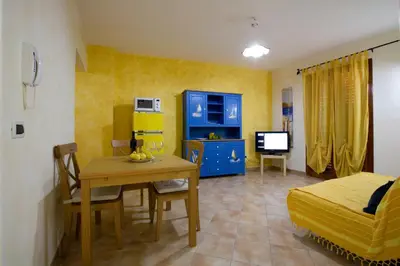 a living room with a dining table and a bedroom at Balconi Sul Mare Appartamenti in Castellammare del Golfo