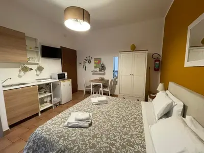 a bedroom with a bed and a kitchen and a table at Punto Politeama in Palermo