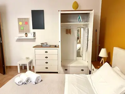a bedroom with a dresser and a bed with towels at Punto Politeama in Palermo