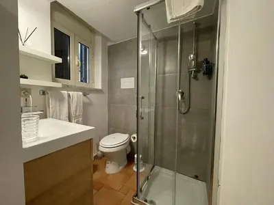 a bathroom with a toilet and a glass shower at Punto Politeama in Palermo