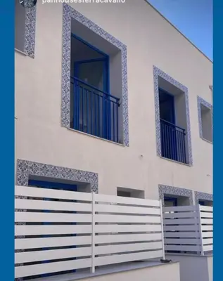 a white building with blue windows and a fence at Panhouse in Palermo