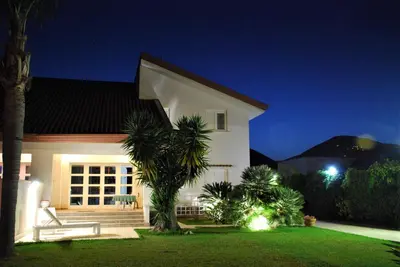 a white house with palm trees in front of it at Villa Ginevra in Mondello