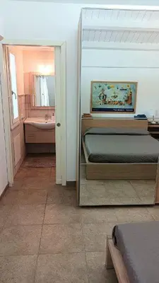 a bedroom with a bed and a bathroom with a sink at Villa Ginevra in Mondello