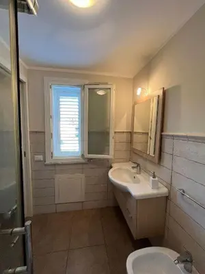 a bathroom with a sink and a toilet and a window at Villa Ginevra in Mondello