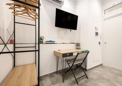 a room with a desk and a tv on a wall at Onda blu in Palermo