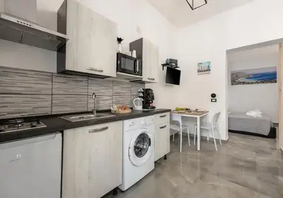 a kitchen with a washing machine and a sink at Onda blu in Palermo