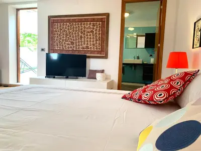 a bedroom with a large white bed with a flat screen tv at Daydream in Trabia