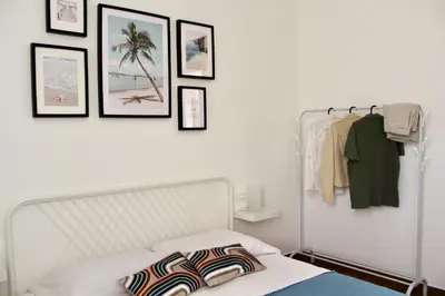 a bedroom with a bed and framed pictures on the wall at Zahira Apartment in San Vito lo Capo