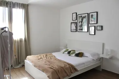 a white bedroom with a bed with a blanket on it at Zahira Apartment in San Vito lo Capo