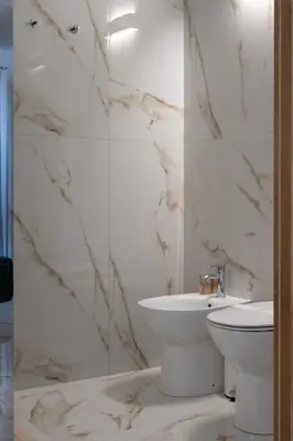 a white bathroom with a sink and a toilet at Ma Gra Ví in Terrasini