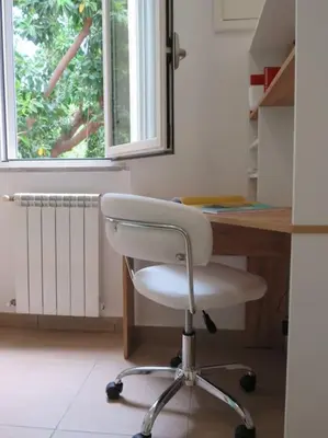 a white chair sitting in front of a desk with a window at Relax nel verde- GioDaPi Palm in Palermo