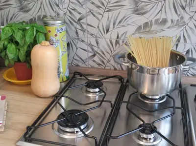 a stove top with a pot of spaghetti on it at Relax nel verde- GioDaPi Palm in Palermo
