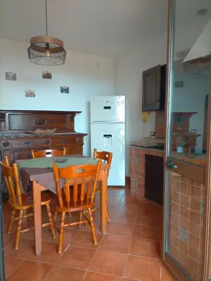 a kitchen with a table and chairs and a refrigerator at Menzel el Emir in Misilmeri