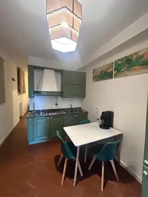 a kitchen with green cabinets and a table and chairs at Mondello suite apartment in Mondello