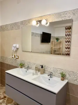 a white bathroom sink with a mirror above it at Affittacamere bm in Palermo