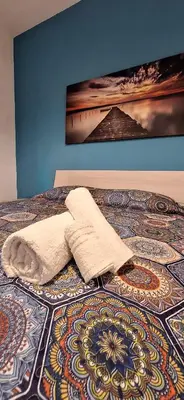 a bed with a towel laying on a rug on it at Sweet Dreams a casa di Alex in Palermo