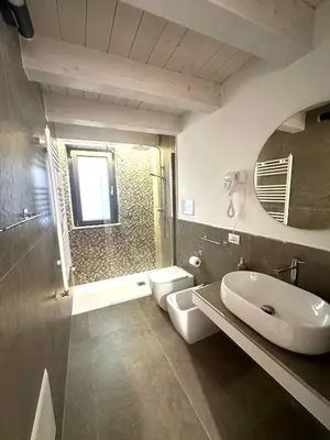 a bathroom with a sink and a toilet and a mirror at L'Oasi del Tirreno in Lascari