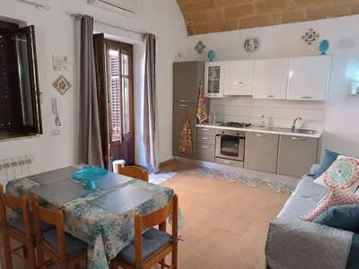 a kitchen and living room with a table and a couch at Casa Atlanna in Terrasini